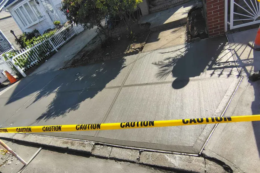 Replaced sidewalk taped off to cure in Jamaica Hills, Queens, sidewalk repair by Sidewalk Repair Near Me in NYC