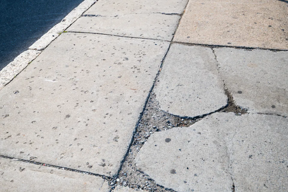 Cracked and broken concrete sidewalk flags