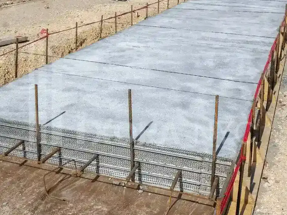 Concrete foundation slab with steel reinforcement and dowels along its edge, foundation work by Sidewalk Repair Near Me in NYC