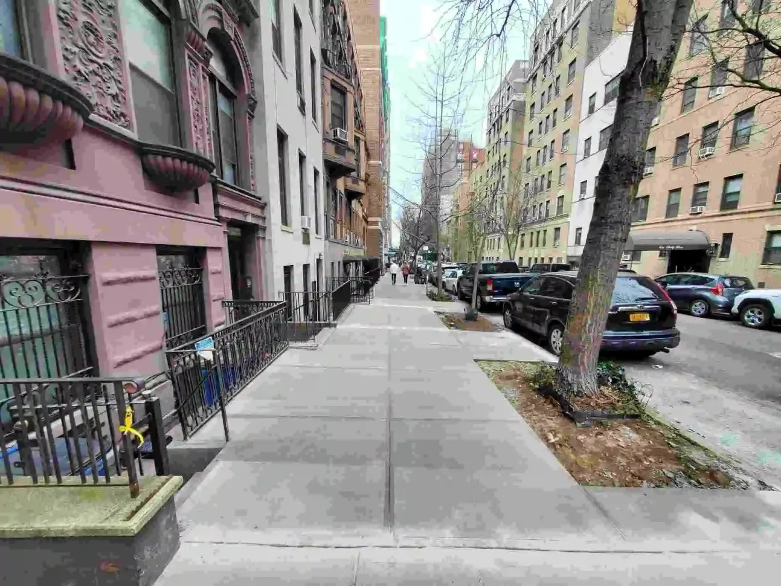 Finished concrete sidewalk with a tree pit on a block of apartment buildings, sidewalk repair by Sidewalk Repair Near Me in NYC