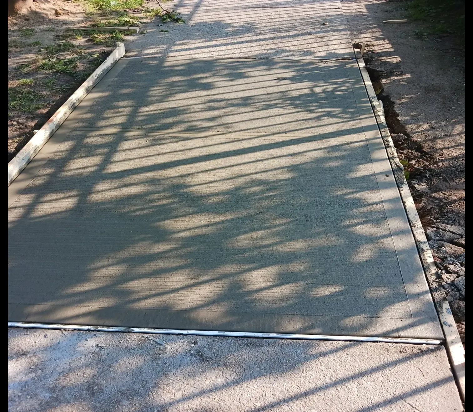 Fresh concrete sidewalk flag in dappled shade, sidewalk repair by Sidewalk Repair Near Me in NYC