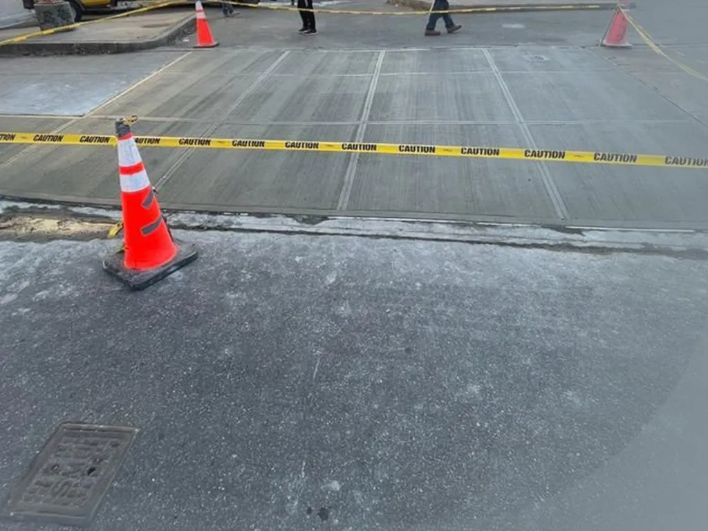 Fresh concrete sidewalk flags taped off beside the street with a traffic cone, sidewalk repair by Sidewalk Repair Near Me in NYC