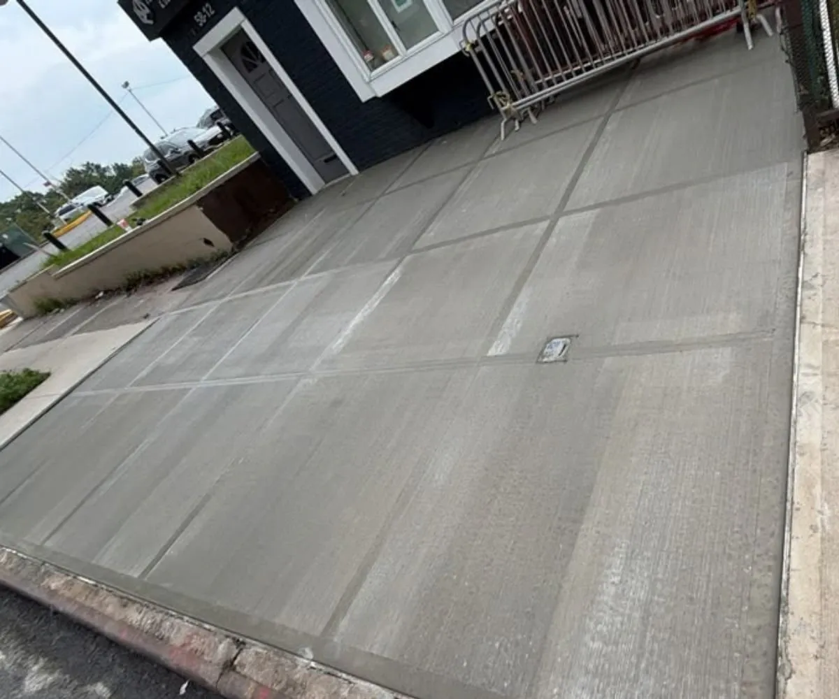 New concrete sidewalk and curb outside a commercial building, sidewalk repair by Sidewalk Repair Near Me in NYC