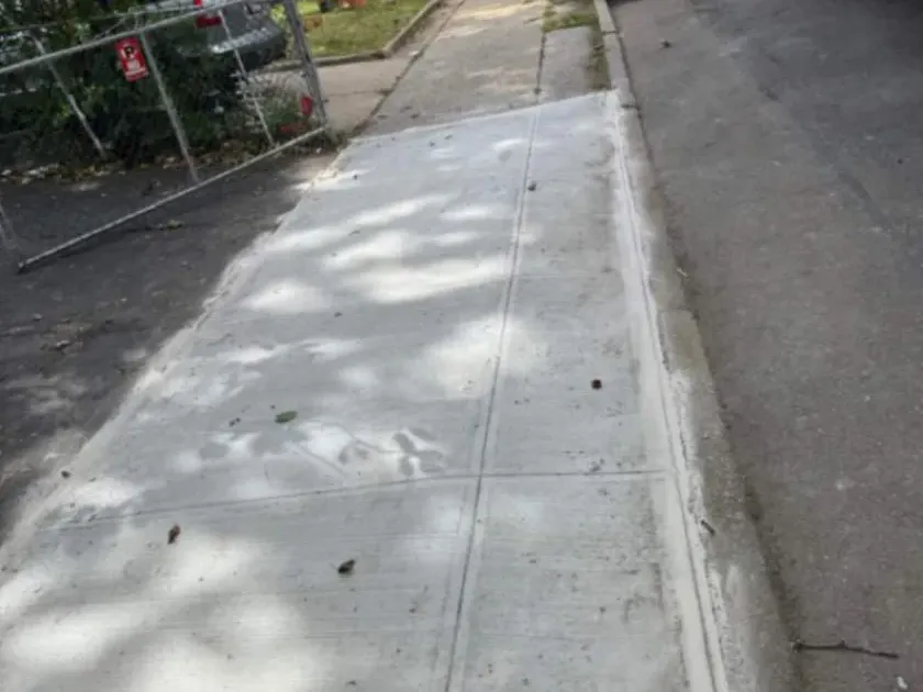 New concrete sidewalk along the curb in Jamaica, Queens, sidewalk repair by Sidewalk Repair Near Me in NYC