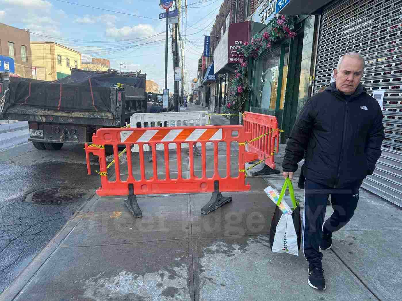 Crack in concrete with small green plants growing through it